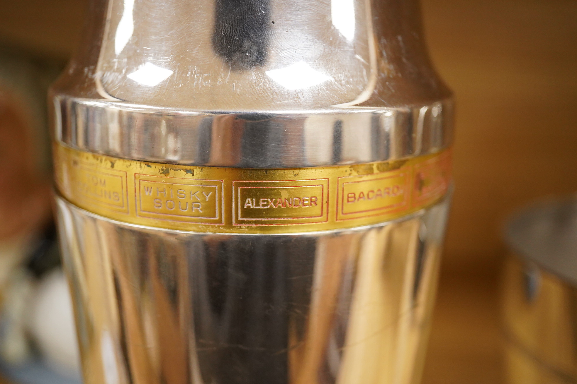 A mid 20th century silver plated patent cocktail shaker with recipes, two other cocktail shakers and an ice bucket, largest 28cm high